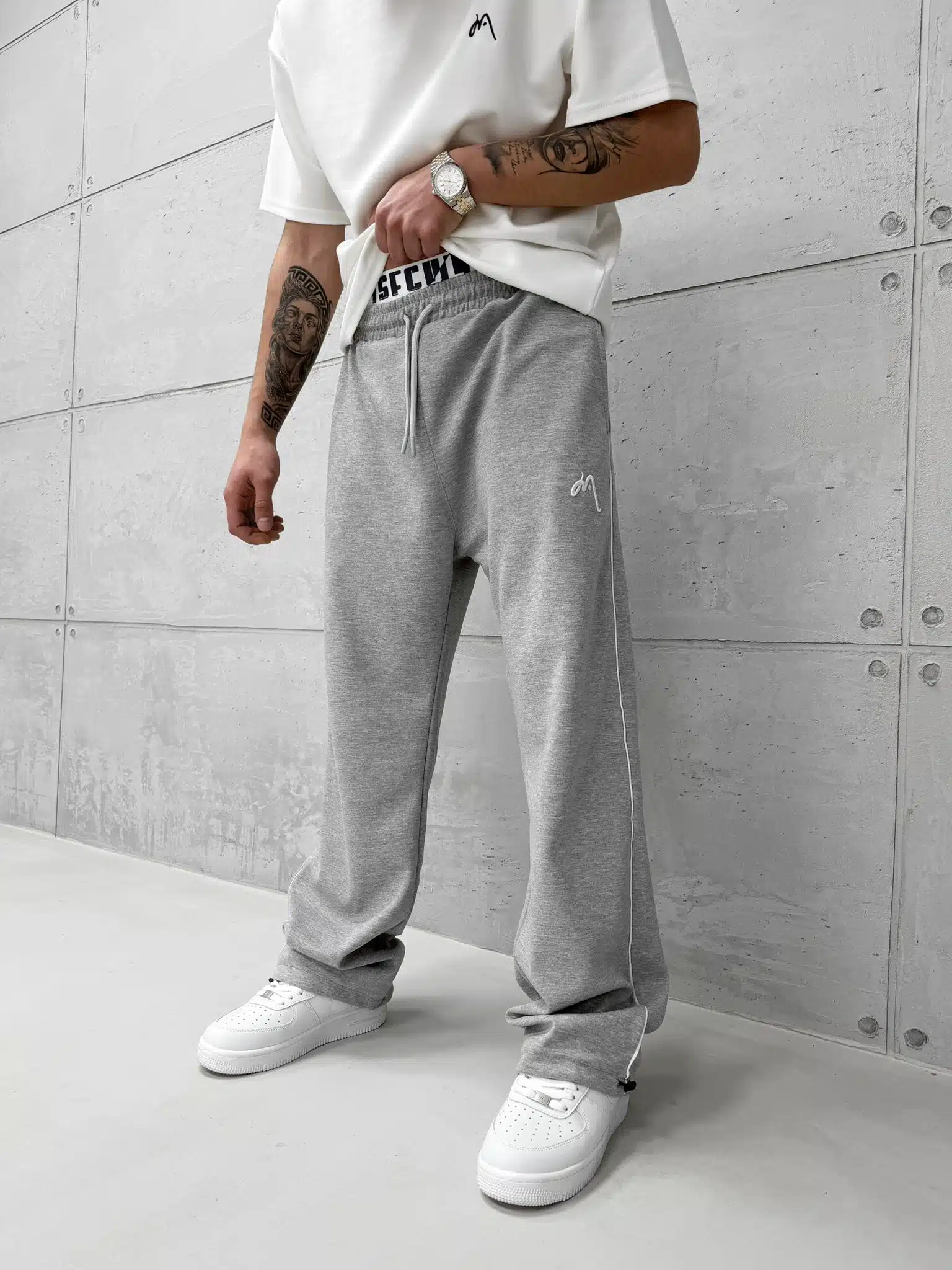 WhatsApp Image 2026-02-06 at 16.43.32 Premium İmzalı Seri Nakışlı Şeritli Stoper Paça Baggy Eşofman – Gri - Görsel 1