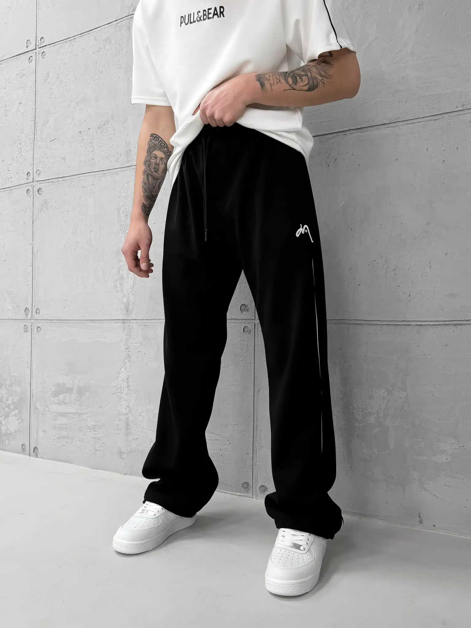 WhatsApp Image 2026-02-06 at 16.47.01 Premium İmzalı Seri Nakışlı Şeritli Stoper Paça Baggy Eşofman – Siyah - Görsel 1